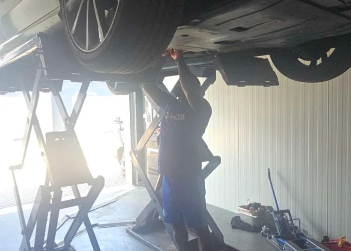 Monteur werkt onder een opgekrikte auto